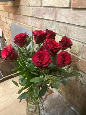 a bouquet of red roses in a vase on a table at Apartament Francuzka in Kraków