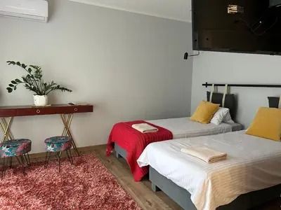 a room with two beds and a table and chairs at Apartament Francuzka in Kraków