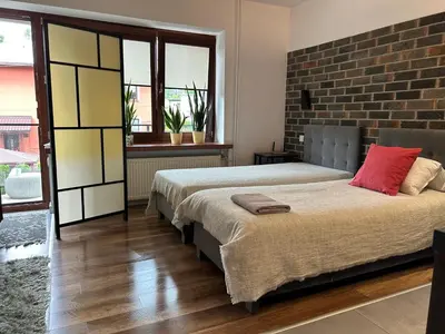 a bedroom with two beds and a brick wall at Apartament Francuzka in Kraków