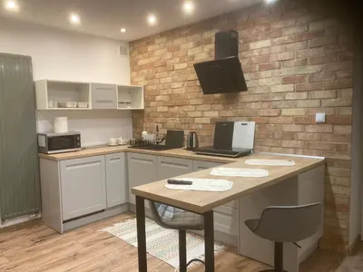 a kitchen with a table and a brick wall at Apartament Francuzka in Kraków