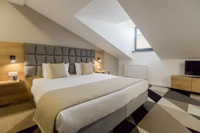 a bedroom with a large white bed and a window at Lwowska 1 in Kraków