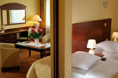 a hotel room with a bed and a table with flowers on it at Dworek Emilli in Wieliczka