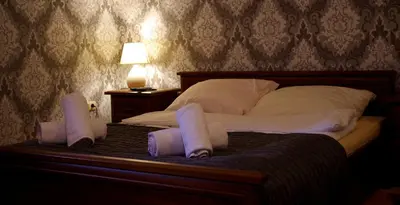 a bed with two pillows and two towels on it at Dworek Emilli in Wieliczka
