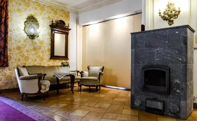 a living room with a fireplace and a table and chairs at Dworek Emilli in Wieliczka