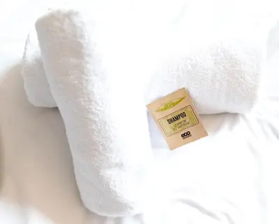 a white towel with a box on a bed at Dworek Emilli in Wieliczka