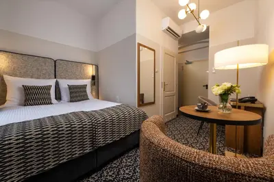 a hotel room with a bed and a table and a chair at Hotel Palladian in Kraków