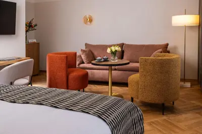 a living room with a couch and a table and chairs at Hotel Palladian in Kraków
