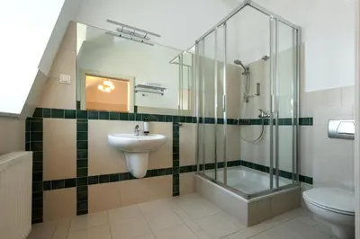 a bathroom with a sink and a shower and a toilet at Hotel Palladian in Kraków