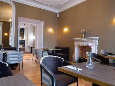 a restaurant with tables and chairs and a fireplace at Hotel Palladian in Kraków