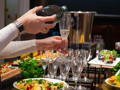 a person is pouring champagne into glasses on a table at Hotel Palladian in Kraków