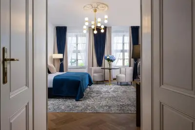 a bedroom with a bed and a chandelier at Hotel Palladian in Kraków