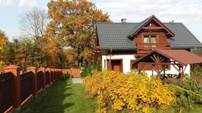 a wooden house with a fence in front of it at Apartament Pozytywka in Tenczynek