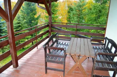 a wooden table and two chairs on a deck at Dom na Mosornym Groniu in Zawoja