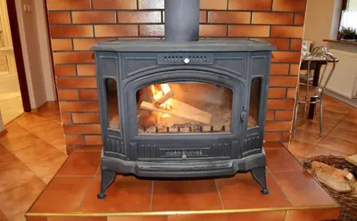 a black stove with a fire in a room at Dom na Mosornym Groniu in Zawoja