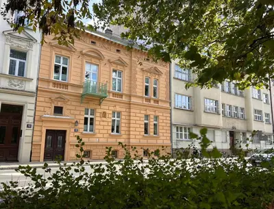 a large brick building with a balcony in front of it at Yourplace M57 Apartments in Kraków