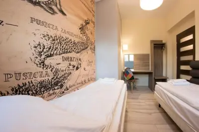two beds in a room with a poster on the wall at Yourplace M57 Apartments in Kraków