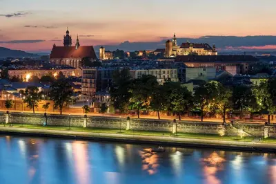 a city skyline at night with a river at Yourplace M57 Apartments in Kraków