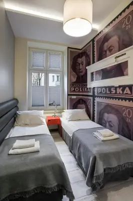 two beds in a room with posters on the wall at Yourplace M57 Apartments in Kraków