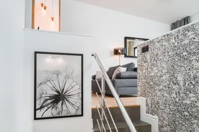 a staircase in a living room with a picture on the wall at Flower Residence in Kraków