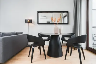 a dining room with a table and chairs and a couch at Flower Residence in Kraków