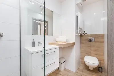 a bathroom with a toilet and a glass shower at Flower Residence in Kraków