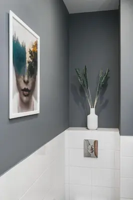 a bathroom with a picture and a vase with a plant at Flower Residence in Kraków