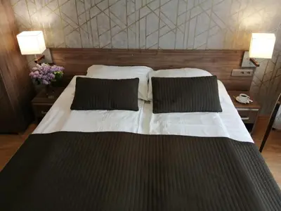 a bedroom with a large bed with two pillows at Hotel Zakliki in Kraków