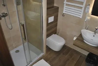 a bathroom with a shower and a toilet and a sink at Hotel Zakliki in Kraków
