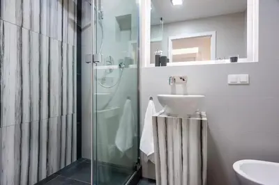 a bathroom with a glass shower and a sink at Zwierzyniecka Old Town Apartments by Otium in Kraków
