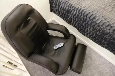 a black chair sitting next to a bed at Zwierzyniecka Old Town Apartments by Otium in Kraków