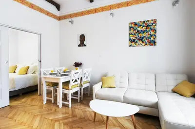 a white living room with a white couch and a table at Zwierzyniecka Old Town Apartments by Otium in Kraków