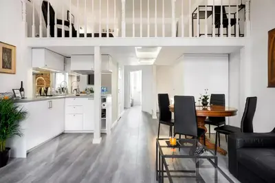 a living room and kitchen with a table and chairs at Zwierzyniecka Old Town Apartments by Otium in Kraków