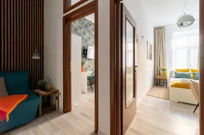 a living room with a blue chair and a mirror at Horizon Apartments - Plac Nowy in Kraków