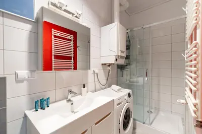 a bathroom with a sink and a washing machine at Horizon Apartments - Plac Nowy in Kraków