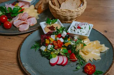 two plates of food on a wooden table at Horizon Apartments - Plac Nowy in Kraków