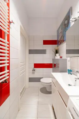 a bathroom with a white toilet and red accents at Horizon Apartments - Plac Nowy in Kraków