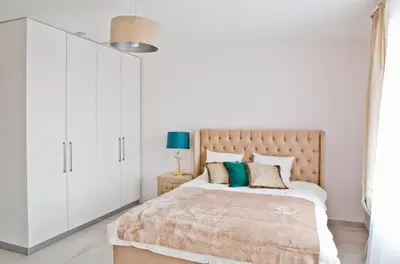 a bedroom with a large bed with white cabinets at Elegant City Center Apartment 7A in Kraków