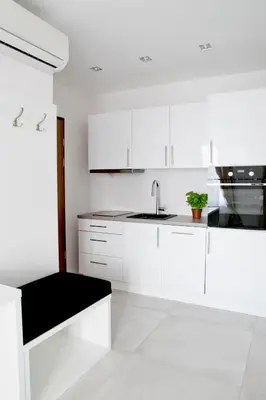 a white kitchen with white cabinets and a sink at Elegant City Center Apartment 7A in Kraków