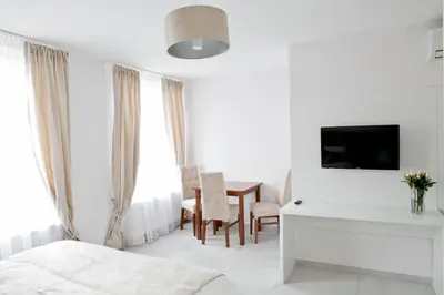 a bedroom with a bed and a desk and a table at Elegant City Center Apartment 7A in Kraków