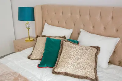 a bed with green and white pillows on it at Elegant City Center Apartment 7A in Kraków