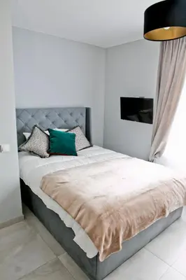 a bedroom with a large bed with a gray headboard at Elegant City Center Apartment 7B in Kraków