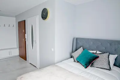 a bedroom with a bed with green and white pillows at Elegant City Center Apartment 7B in Kraków