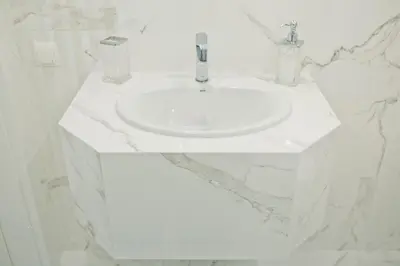 a white sink in a white bathroom with marble walls at Elegant City Center Apartment 7B in Kraków