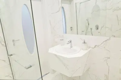 a white bathroom with a sink and a mirror at Elegant City Center Apartment 7B in Kraków