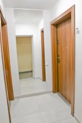 a hallway with a door and a mirror at Elegant City Center Apartment 7B in Kraków
