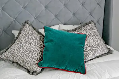 a green pillow sitting on a bed with pillows at Elegant City Center Apartment 7B in Kraków