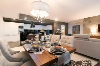 a dining room and living room with a table and chairs at Kings City - Skawińska Apartment in Kraków