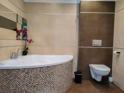 a bathroom with a bath tub and a toilet at Kings City - Skawińska Apartment in Kraków