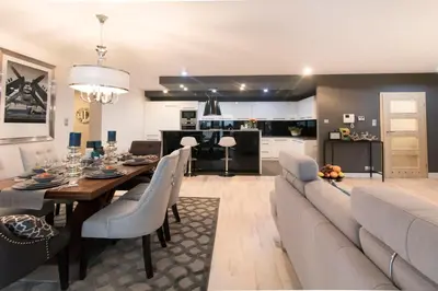 a dining room and living room with a table and a couch at Kings City - Skawińska Apartment in Kraków