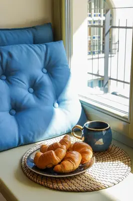 a plate of croissants and a cup of coffee on a table at Avium Old Town Apartments in Kraków